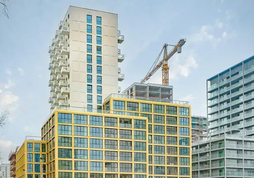 Afbeelding van een hoogbouwproject met een hijskraan en nieuwe kantoorruimtes.