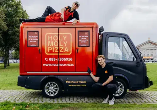 Mobiele pizza kiosk met creatieve ontwerp en branding voor catering.